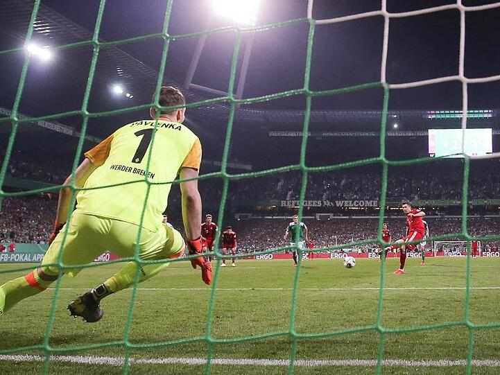 Bremens Torwart Jiri Pavlenka (l) kann den Elfmeter von Münchens Robert Lewandowski (r hinten) nicht parieren. Foto: Christian Charisius