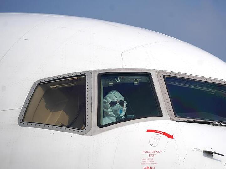 Ein Pilot mit Schutzanzug im Cockpit auf dem Internationalen Flughafen Wuhan-Tianhe.