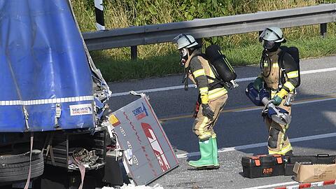 Einatzkräfte der Feuerwehr am beschädigten Sattelzug.