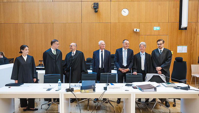 Der Kl&auml;ger Alexander Egger (3.v.r.) steht im  Gerichtssaal zwischen zwei seinen Anw&auml;lten Maximilian Schmid (r-l), Benno Ziegler, Walter Frenz, Bernhard Stolz, Pascal Friton und Juliana Wimmer. Das Bayerische Oberste Landesgericht befasst sich mit der Klage, dass gro&szlig;e Festzelte am Oktoberfest nicht nach europ&auml;ischem Vergaberecht ausgeschrieben werden.