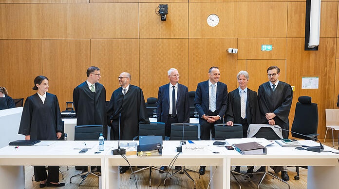 Der Kl&auml;ger Alexander Egger (3.v.r.) steht im  Gerichtssaal zwischen zwei seinen Anw&auml;lten Maximilian Schmid (r-l), Benno Ziegler, Walter Frenz, Bernhard Stolz, Pascal Friton und Juliana Wimmer. Das Bayerische Oberste Landesgericht befasst sich mit der Klage, dass gro&szlig;e Festzelte am Oktoberfest nicht nach europ&auml;ischem Vergaberecht ausgeschrieben werden.