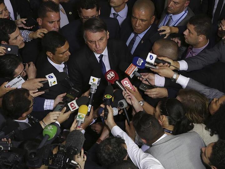 Brasiliens Präsident Jair Bolsonaro (M) spricht mit Journalisten, nachdem er das Dekret zum gelockerten Waffenrecht unterzeichnet hat.