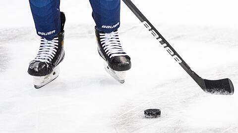 Ein Eishockeyspieler spielt den Puck.