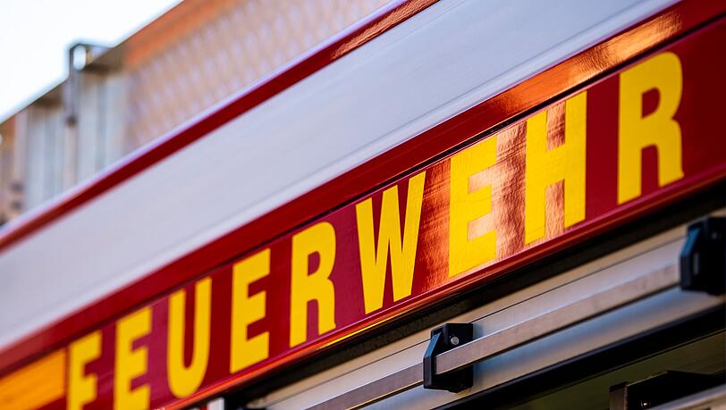 Auf dem Einsatzfahrzeug ist in gelber Farbe der Schriftzug "Feuerwehr" zu lesen.