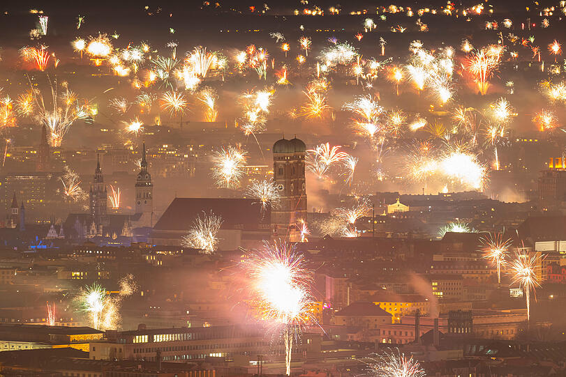 Silvesterfeuerwerk erhellt den Himmel über der Münchner Innenstadt.