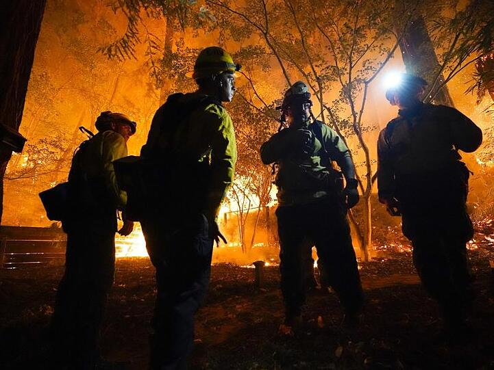 Feuerwehrleute besprechen das weitere Vorgehen bei Löscharbeiten.