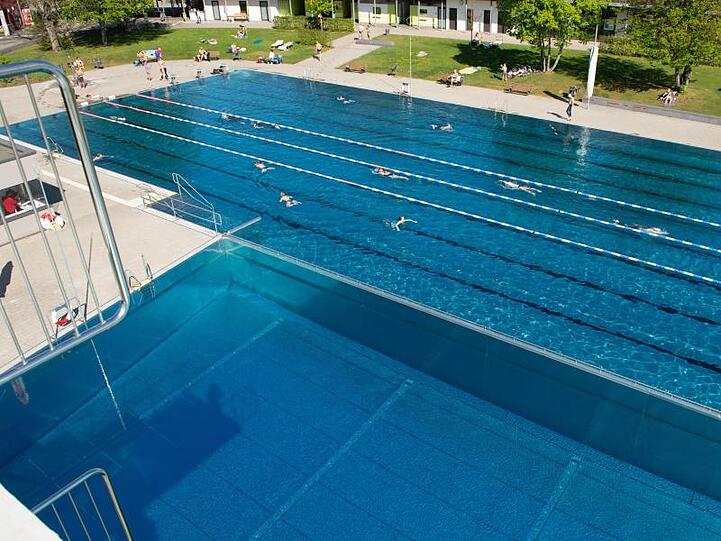 Besucher schwimmen durch das Becken im Westbad in Nürnberg. Foto: Timm Schamberger