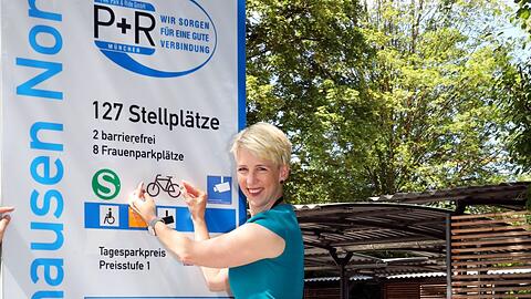 Katrin Habenschaden zeigt das neue Schild mit Radl-Symbol in Lochhausen.
