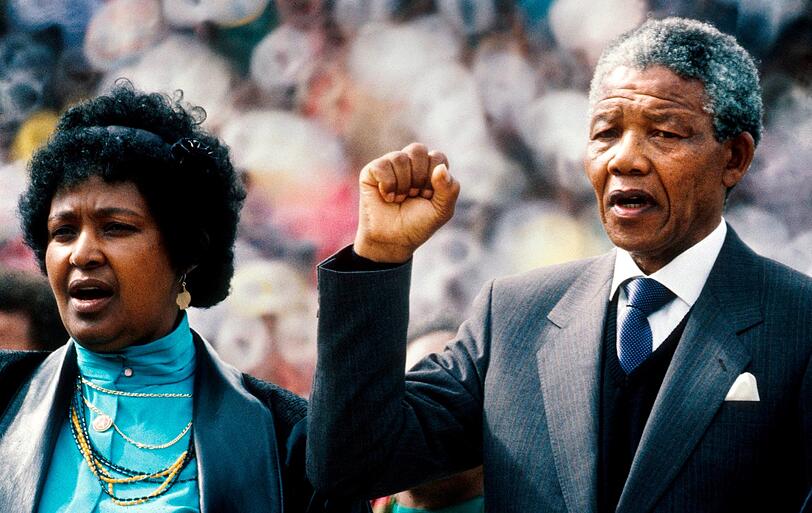 1990 steht Nelson Mandela mit geballter Faust nebem seiner damalige Frau Winnie Mandela während der Welcome Home Rally' im Township Soweto in Johannesburg.