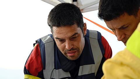 Simon Friz (links), Teamleiter der insgesamt 67 Feuerwehrleute aus Bonn, Düsseldorf und Celle, die bei der Bekämpfung schwerer Waldbrände in Spanien geholfen haben, bei einer Einsatzbesprechung. Für die Deutschen ging es auch darum, das Wissen ihrer südeuropäischen Kollegen mit nach Deutschland zu nehmen. (Archivbild)