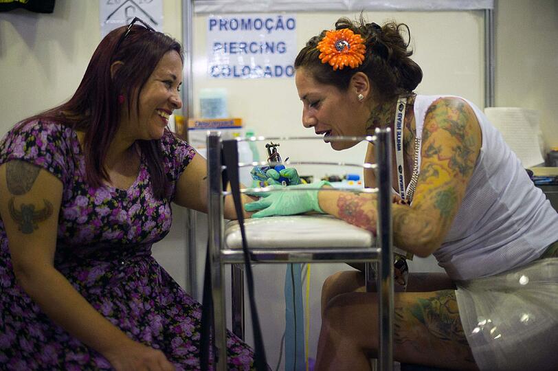 Tätowierungs-Päpstin: Tattoo-Künstlerin Daniela Pabst (r.) bei der Arbeit auf der Messe.