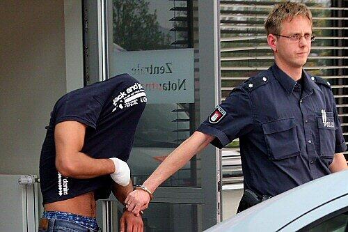 Ein Polizist führt den Tatverdächtigen ab