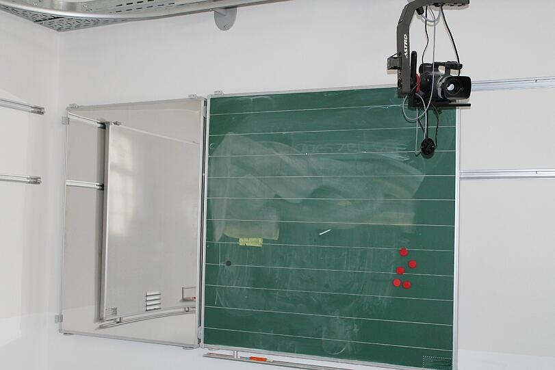 Kameras an den Wänden und der Tafel zeigen den Kommilitonen im Nebenraum, wie sich die Lehrer in ihrem Unterricht anstellen.