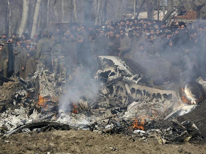 Kaschmirische Dorfbewohner versammeln sich bei den Trümmern eines indischen Kampfflugzeuge im Bezirk Budgam im indischen Teil Kaschmirs.