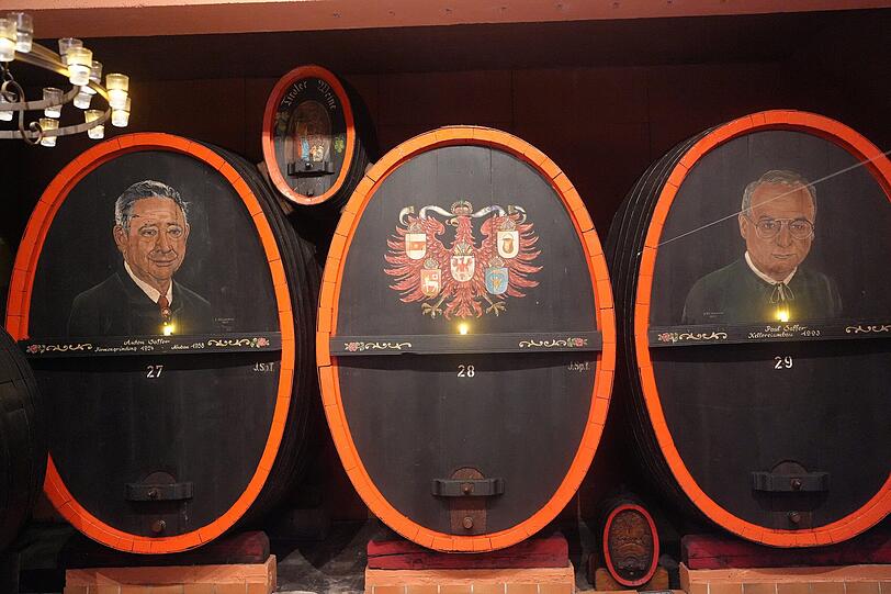 Auf den F&auml;ssern sind die fr&uuml;heren Chefs der Saffer Wein GmbH abgebildet: Anton Saffer (l.) und Paul Saffer (r.).