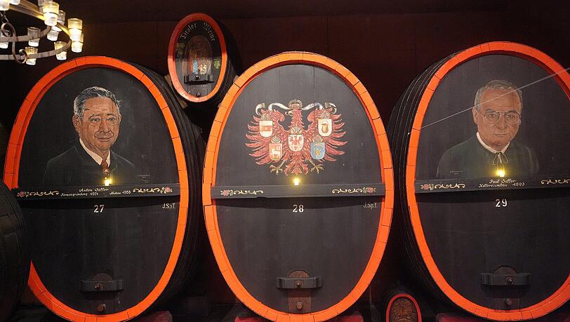 Auf den F&auml;ssern sind die fr&uuml;heren Chefs der Saffer Wein GmbH abgebildet: Anton Saffer (l.) und Paul Saffer (r.).