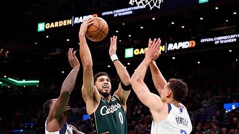 Bostons Jayson Tatum (0) zieht zum Korb zwischen Dorian Finney-Smith (l) und Dwight Powell von den Dallas Mavericks.