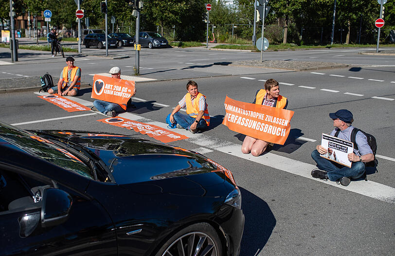 Klimaaktivisten der Gruppe "Letzte Generation" während der Straßenblockade am Ende der A94 nahe der Messe München, wo am Dienstag die IAA 2023 startet.