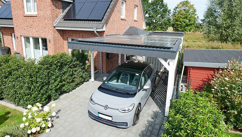 Ein Elektroauto vor dem Haus, eine Wärmepumpe dahinter und Solarzellen auf dem Dach - so können Verbraucher und Verbraucherinnen deutlich CO2 sparen.