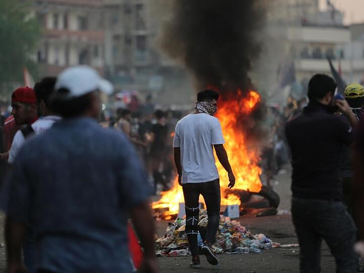 Demonstranten verbrennen Reifen während eines Protestes in Bagdad.