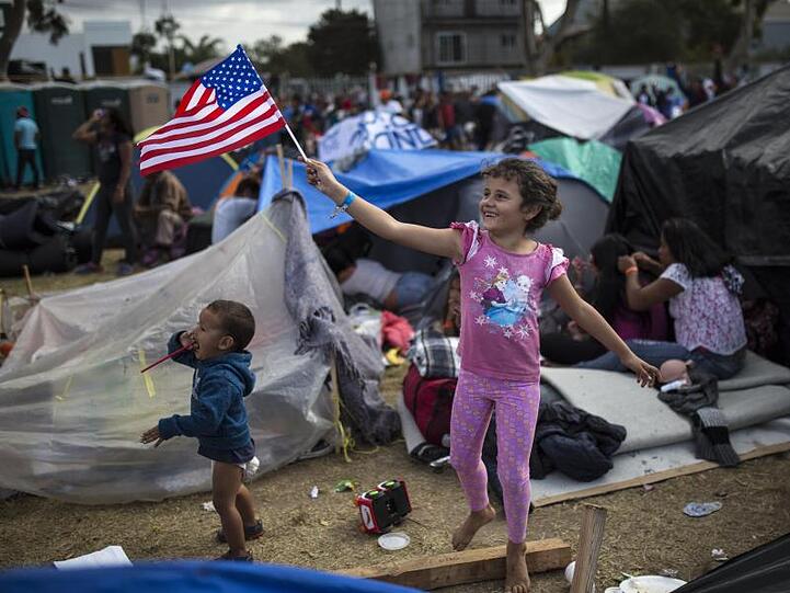 Ein Kind aus Honduras schwenkt eine amerikanische Flagge in Richtung eines Hubschraubers des US-Grenzschutzes.