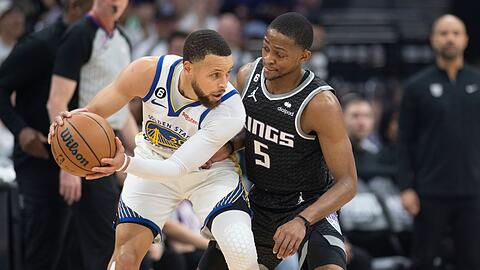 Stephen Curry von den Golden State Warriors wird von De'Aaron Fox von den Sacramento Kings verteidigt.