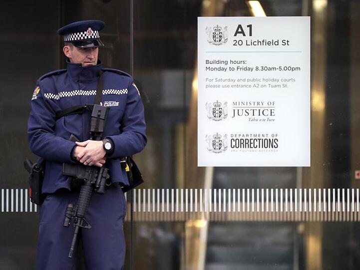 Ein Polizist steht vor dem Eingang zum Gericht in Christchurch. Der mutmaßliche Attentäter wurde bei einer Anhörung per Video-Übertragung zugeschaltet.