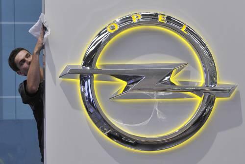 Ein Opel-Mitarbeiter poliert das neue Logo des Autobauers: Für die Beschäftigten geht die Zitterpartie weiter.