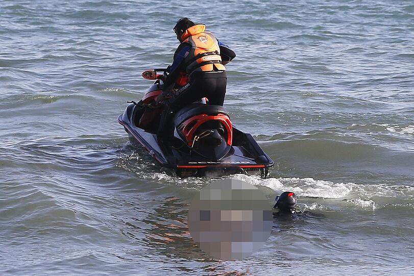 Einsatzkräfte der "Proteccion Civil" ziehen eine der drei Leichen aus dem Wasser.