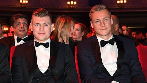 Toni Kroos (l) und sein Bruder Felix Kroos (r) sitzen bei einer Veranstaltung nebeneinander.