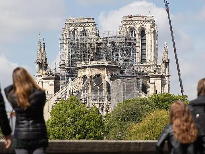 Ein Kran steht neben der schwer beschädigten Pariser Kathedrale Notre-Dame.