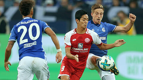 Thilo Kehrer (l) und Bastian Oczipka (r) von Schalke versuchen Yoshinori Muto (M) von Mainz den Ball abzunehmen