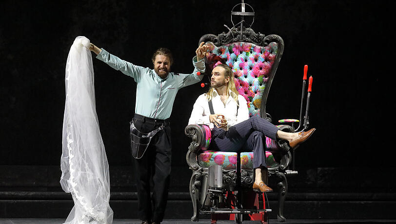 Konstantin Krimmel (Figaro, l.) und Huw Montague Rendall (Graf) und der ominöse Luststuhl in Evegny Titovs Mozart-Inszenierung im Nationaltheater.