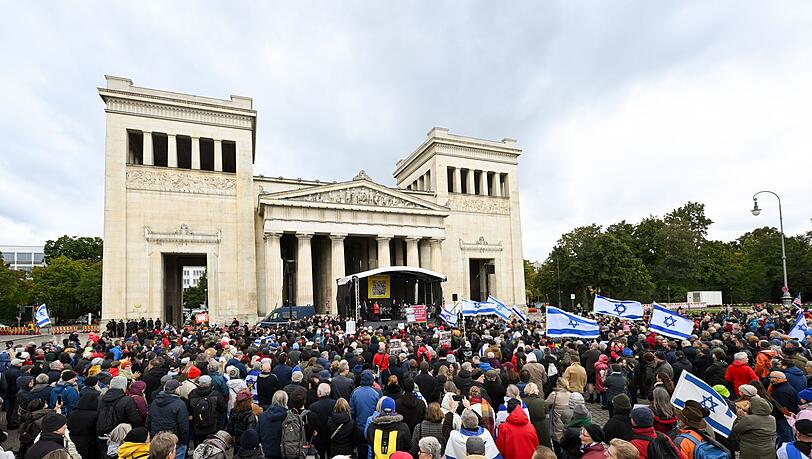 Menschen stehen bei der Kundgebung "Dach gegen Hass" gegen Antisemitismus am Königsplatz in München.