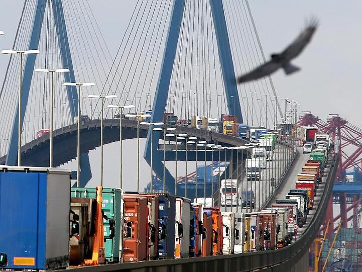 Mit Containern beladene Lastwagen stauen sich auf der Köhlbrandbrücke im Hafen Hamburg.