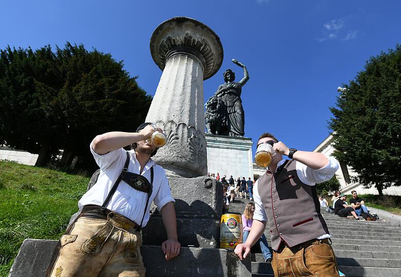 Maximilian (l) und Michael trinken pünklich um 12:00 Uhr ihr mitgebrachtes Bier auf der leeren Theresienwiese.