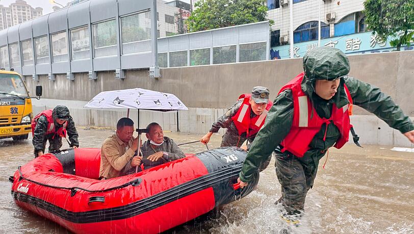 Retter helfen mit Schlauchbooten nach den starken Regenf&auml;llen in Qinzhou.