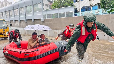 Retter helfen mit Schlauchbooten nach den starken Regenf&auml;llen in Qinzhou.