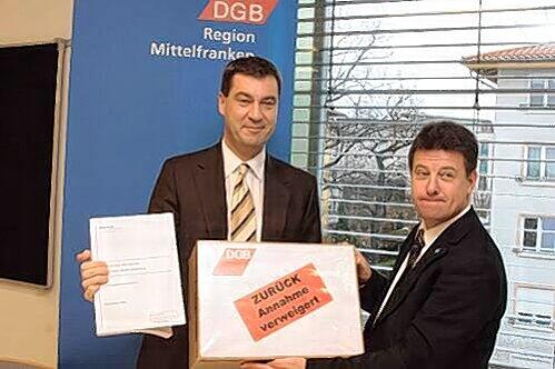 Mittelfrankens DGB-Chef Stephan Doll übergibt die Unterschriften an Minister Markus Söder.