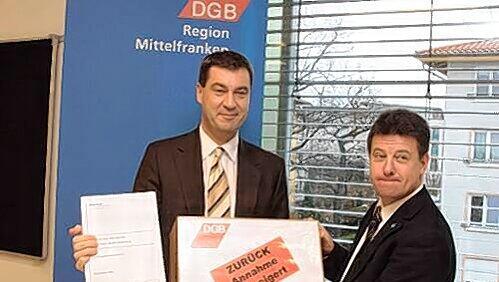 Mittelfrankens DGB-Chef Stephan Doll übergibt die Unterschriften an Minister Markus Söder.