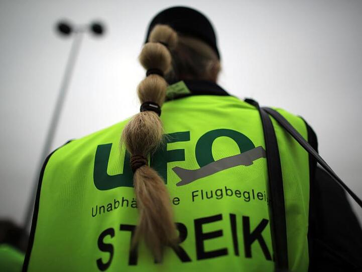 Eine Flugbegleiterin bei einer Kundgebung. Foto: Oliver Berg/dpa