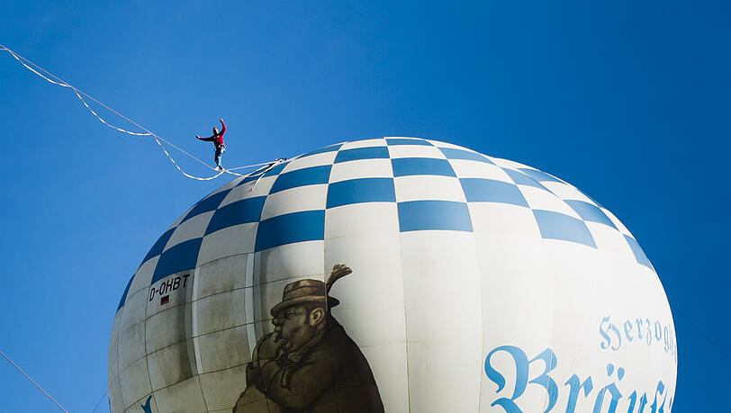 Herterich marschiert am Tegernsee von einem Heißlutballon zum anderen.