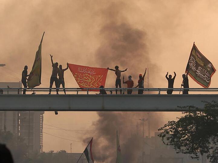Fahnen schwenkende Demonstranten auf einer Brücke: Angeführt werden die Demonstrationen vor allem von jungen Männern.