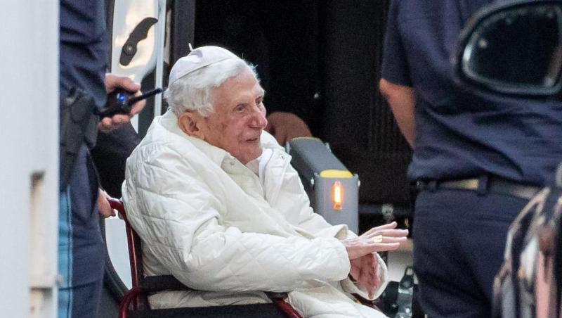 Der emeritierte Papst Benedikt XVI wird in Regensburg mit einem Rollstuhl in einen Bus geschoben. Foto: Daniel Karmann/dpa/Archivbild Der emeritierte Papst Benedikt XVI wird in Regensburg mit einem Rollstuhl in einen Bus geschoben. Foto: Daniel Karmann/dpa/Archivbild