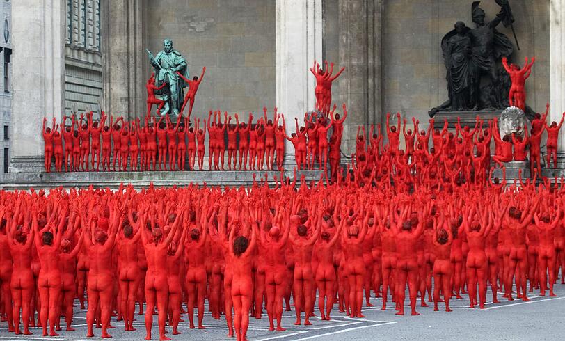 Star-Fotograf Spencer Tunick lässt zur Eröffnung der Opernfestspiele für seine Installation hunderte bunt angemalte Menschen durch München laufen. Das Highlight: Die rot-goldenen Teilnehmer stellen sich an Münchner Monumenten entlang der Ludwigstraße auf. Hier gibts die Bilder!