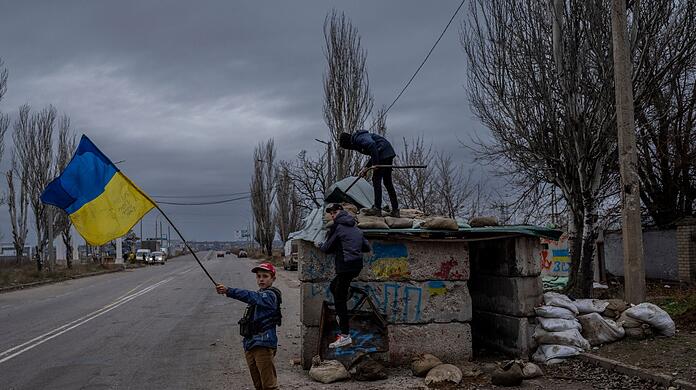 Ukrainische Kinder spielen an einem verlassenen Kontrollpunkt in Cherson.