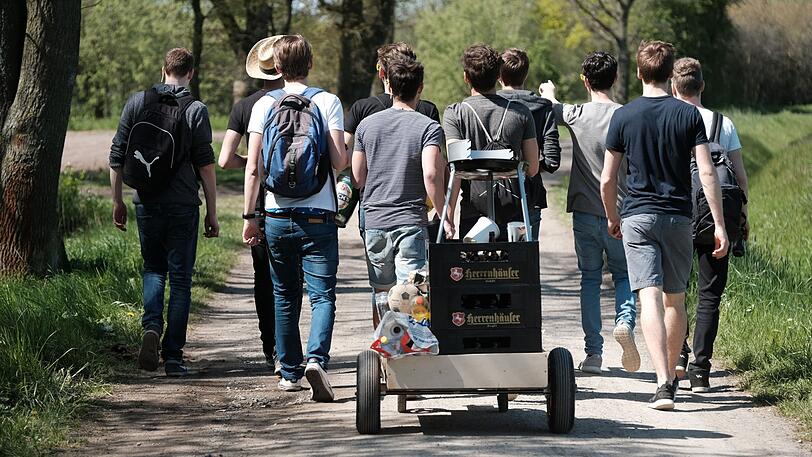 Eine Gruppe junger Männer feiert den Vatertag mit einem mit Bier gefüllten Bollerwagen.