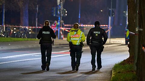 Polizeibeamte streifen durch den abgesperrten Bereich des Geschehens.