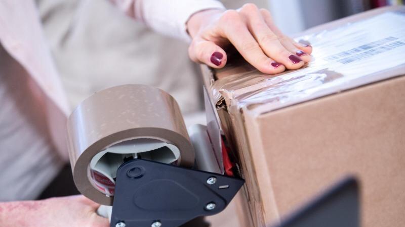 Eine Frau verpackt ein Paket. Muss sie für die Rücksendung bald bezahlen?