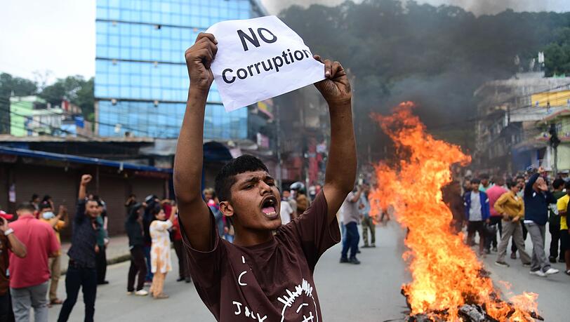 Ein Demonstrant in Nepal hält ein Blatt mit der Forderung nach einem Ende der Korruption hoch.